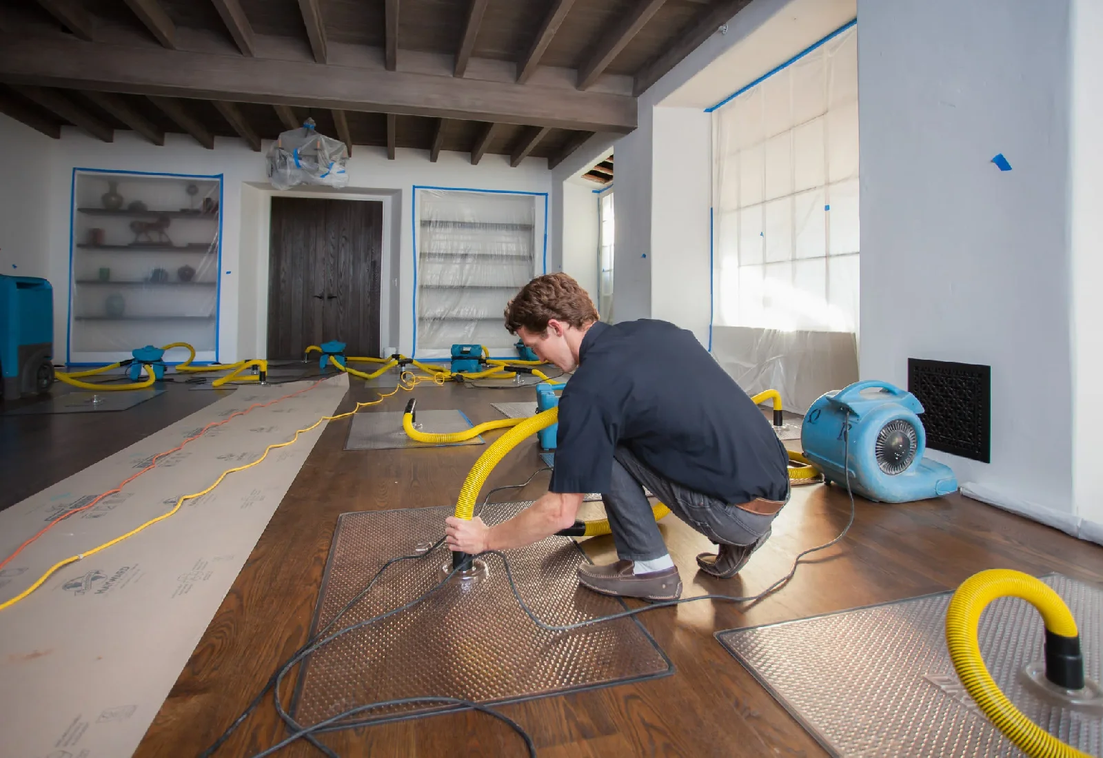 Water damage restoration team working inside flooded property